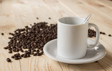 Porcelain coffee cup set with coffee bean on wooden table.