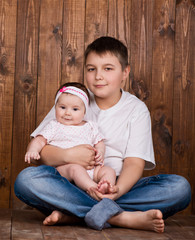 Brother hugging his newborn sister. View from above