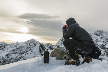 Fototapeta na wymiar Hiker drink hot tea in the winter in the mountains.