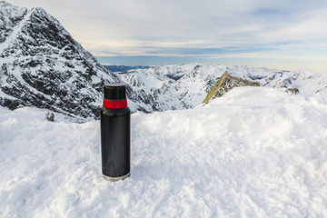 Thermos on the snow in the mountains.