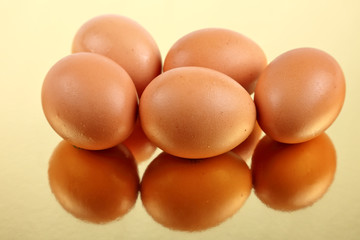 Brown eggs on gold reflective base