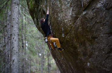 Fototapeta premium Outdoor sport. Rock climber ascending a challenging cliff. Extreme sport climbing.