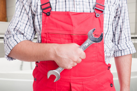 Male fitter holding steel wrench in close-up