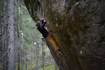 Outdoor sport. Rock climber ascending a challenging cliff. Extreme sport climbing. 