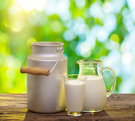 Fresh organic milk on the old wooden table. Nature background.