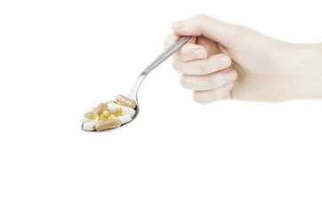 Hand Holding Metal Spoon Full Of Food Supplements Isolated On White Background