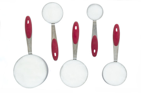 A set of Metal Measuring Cups with Sugar