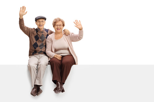 Joyful Senior Couple Sitting On A Panel And Waving