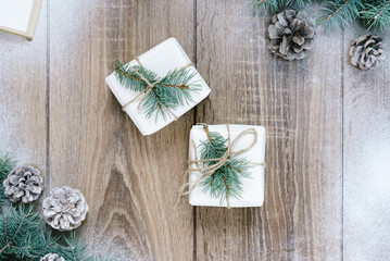 Christmas decorations, pine needles and cones on white wooden background