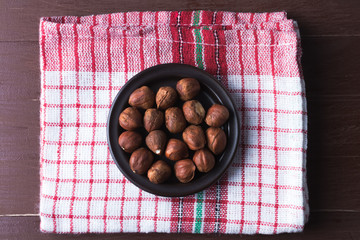 Hazelnuts on a plate with old kitchen dishcloth.