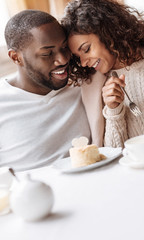 Careful African American couple enjoying the dessert in the cafe