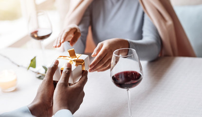 Positive African American man giving the present to his girlfriend