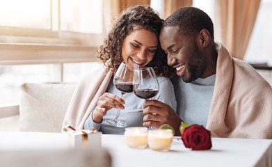 Joyful African American couple drinking wine in the restaurant - Powered by Adobe