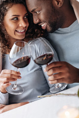 Passionate African American couple drinking wine in the restaurant