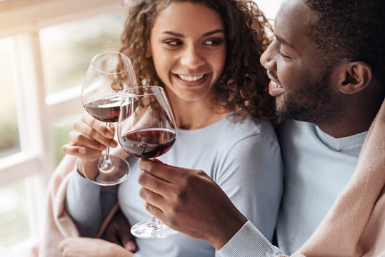 Positive African American couple holding wineglasses in the restaurant