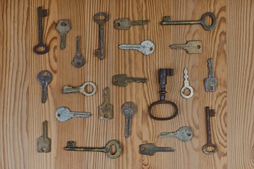 a variety of ancient vintage keys on a wooden table