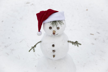 a smiling snowman in red hat of Santa Claus
