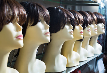 Mannequins with brown-haired and brunet style wigs on shelves