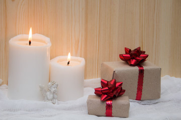 Gift boxes with red bow, white candles and a statuette of an angel. Concept for 14 February, romantic anniversary.
