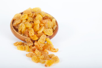 Golden raisins or dried grapes in wooden bowl, white background