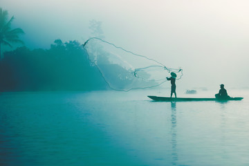 Fisherman casting out his fishing net early in the morning.