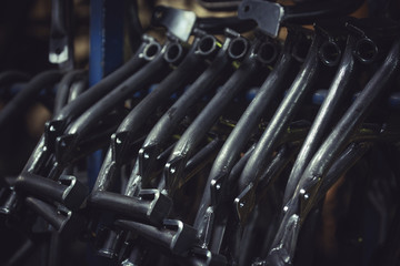 Metal products obtained from steel pipe hanged on a bar in a workshop. Central stand for motorcycles.