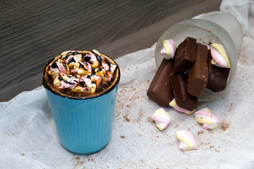 cocoa with marshmallows in  blue mug and chocolates