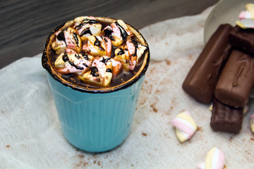 cocoa with marshmallows in  blue mug and chocolates