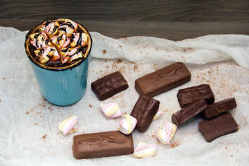 cocoa with marshmallows in  blue mug and chocolates