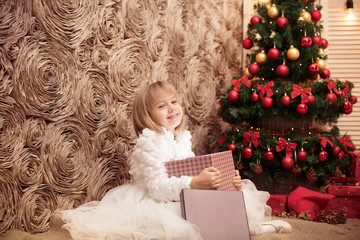 little smiling girl opens a magic Christmas gift box