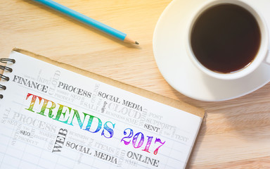 Concept TRENDS 2017 message on book. A pencil and a glass coffee table.Vintage tone.
