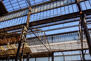 Industrial interior of an old factory building with blue sky