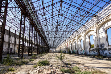 Industrial interior of an old factory building with blue sky