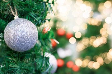 Christmas tree decoration with silver toy, red and yellow bokeh light dots, shallow depth of field