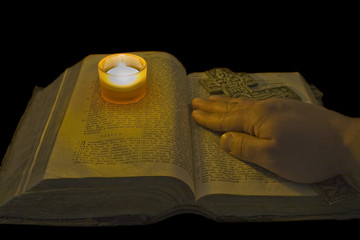 Male hand lies on ancient bible with a big christian cross in th © Aleksandr Kurganov