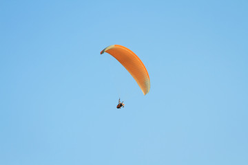Paragliding against clear blue sky