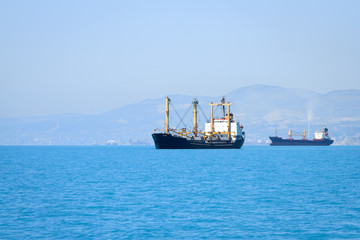 cargo ship sailing in still water near port
