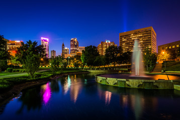 Fototapeta na wymiar Fountain and lake at Marshall Park and the Uptown skyline at nig