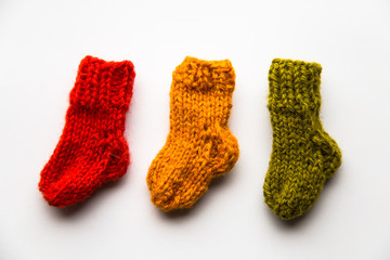 Small, hand knitted woolen socks on light background