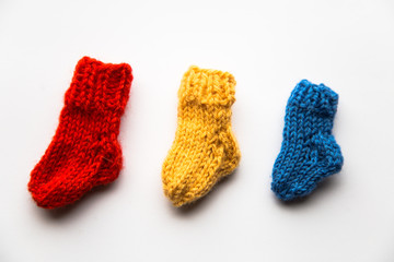 Small, hand knitted woolen socks on light background