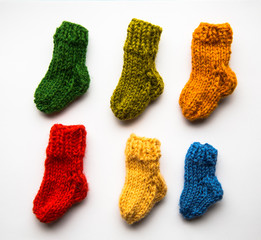 Small, hand knitted woolen socks on light background