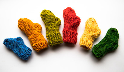 Small, hand knitted woolen socks on light background