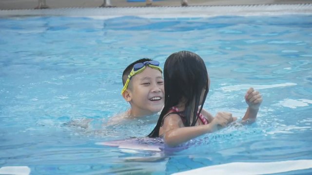 Happy Asian children swimming at pool 