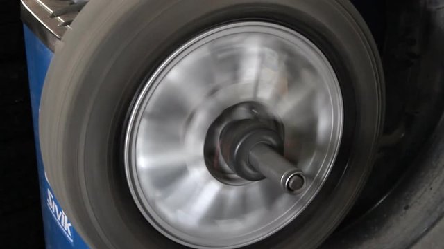 Mechanic balancing car wheel