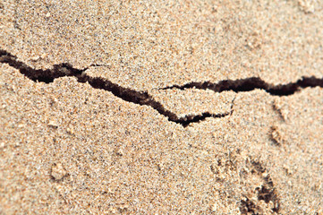 Fototapeta na wymiar Sea shore sand, colored beach sand. The crack on the sand.