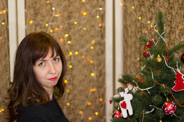 The girl decorates the Christmas tree.