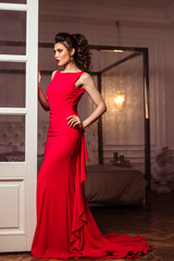 young lady in a gorgeous red evening dress in interior