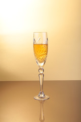 Glass of sparkling shampagne wine on a gold background