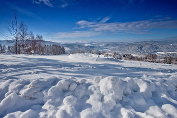 Fototapeta na wymiar Słoneczny zimowy dzień w górskim mieście Muszyna. Sunny winter day in the mountain in Muszyna - Poland. Polish mountain landscape 