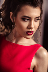 young lady in a gorgeous red evening dress in interior